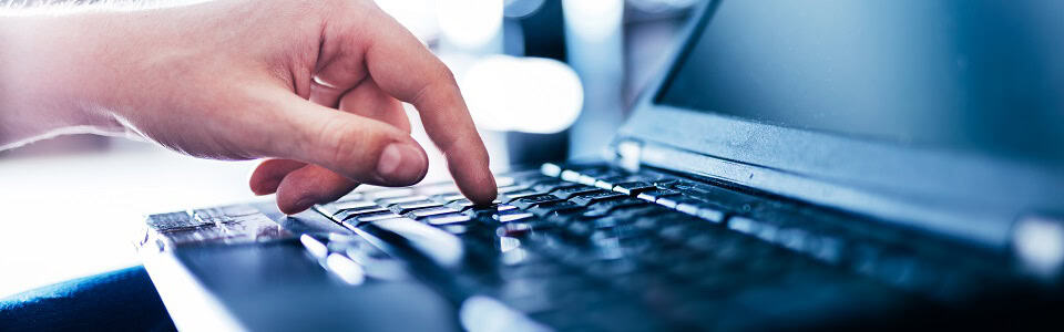 IT specialist pressing button on keyboard in big data center.