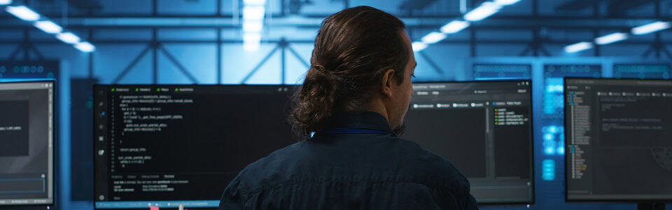 Engineer drinking coffee and programming in server room